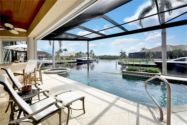 exterior space featuring glass enclosure, a water view, ceiling fan, and a patio area