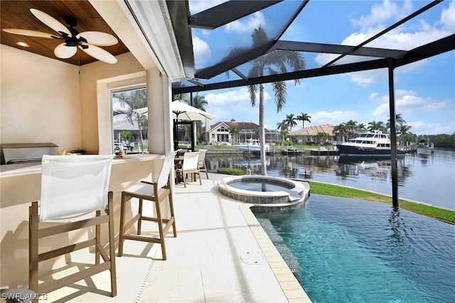 view of pool featuring ceiling fan, an in ground hot tub, glass enclosure, a patio, and a water view