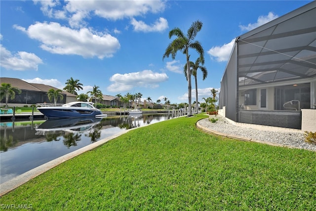 view of yard with a dock, a water view, and a lanai