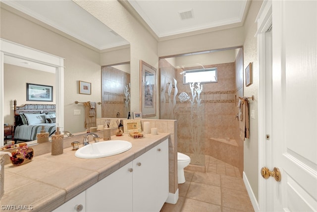 bathroom featuring toilet, crown molding, tiled shower, tile floors, and vanity