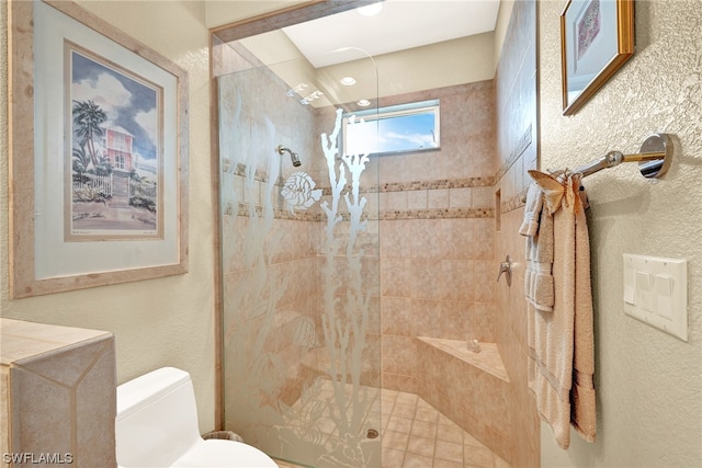 bathroom with toilet and a tile shower