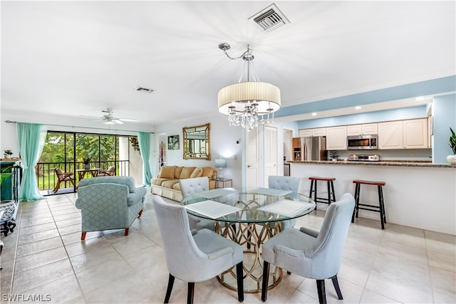 tiled dining room featuring ceiling fan with notable chandelier