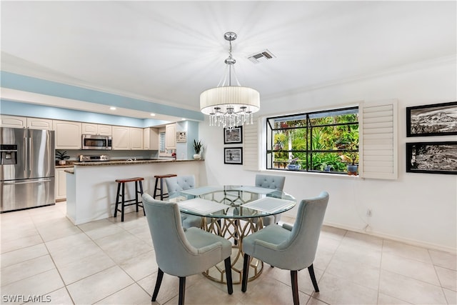 tiled dining room with a chandelier and ornamental molding