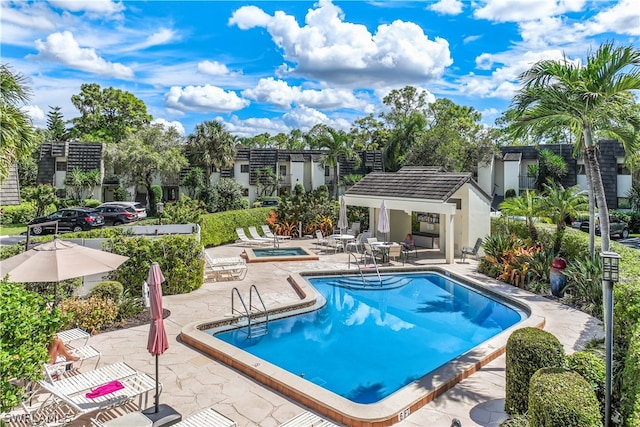 view of pool with a patio and a hot tub