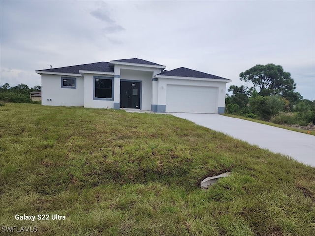 view of front of property with a front yard and a garage