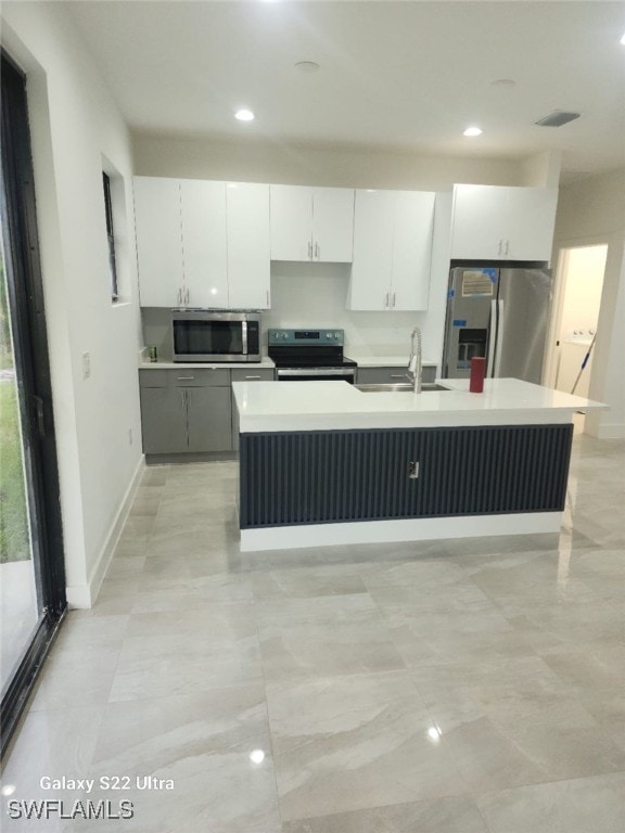 kitchen with a center island with sink, sink, white cabinetry, and stainless steel appliances