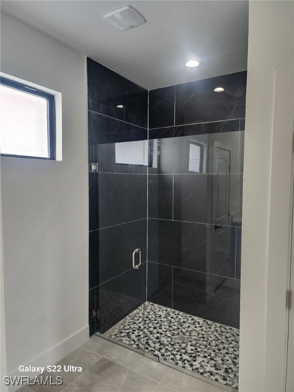 bathroom with tile patterned floors and an enclosed shower