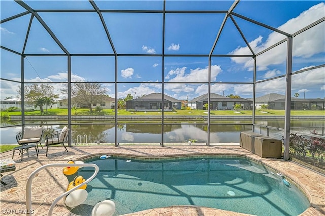 view of swimming pool featuring a patio area, glass enclosure, and a water view