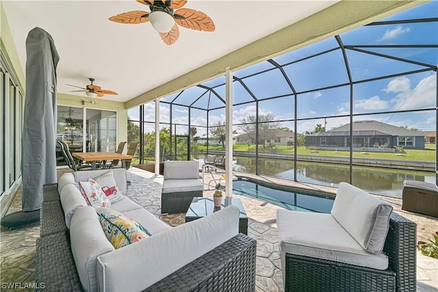 view of patio featuring a lanai, an outdoor hangout area, a water view, and ceiling fan