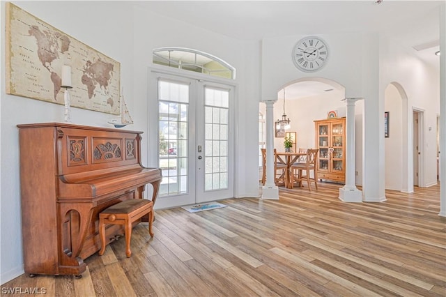 misc room with decorative columns, french doors, and light wood-type flooring