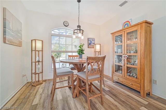 dining space with a chandelier and light hardwood / wood-style floors