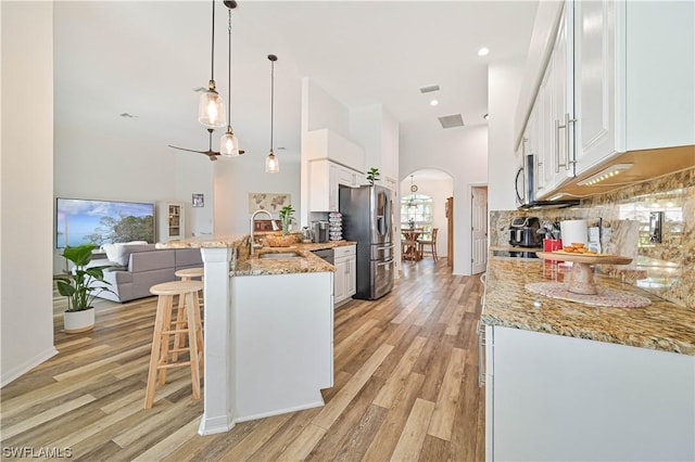 kitchen with hanging light fixtures, sink, and white cabinetry