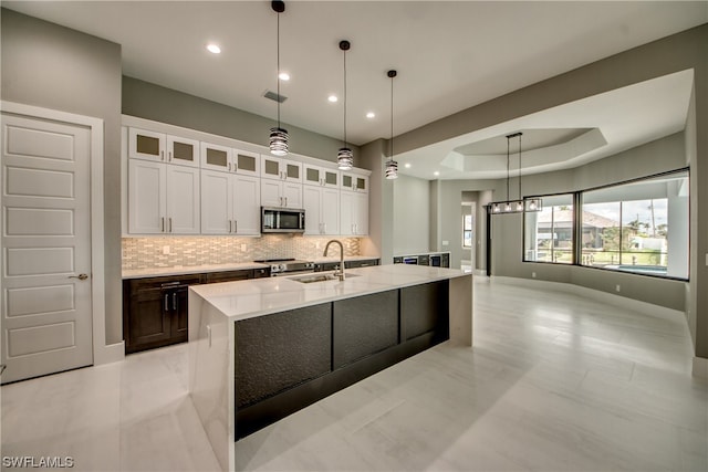 kitchen with white cabinetry, hanging light fixtures, appliances with stainless steel finishes, sink, and light tile floors