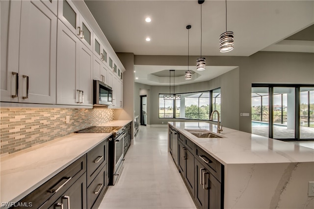 kitchen featuring appliances with stainless steel finishes, decorative light fixtures, white cabinetry, and sink