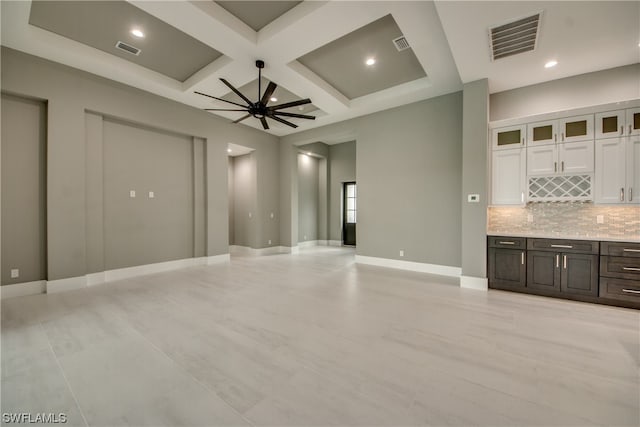 tiled spare room featuring coffered ceiling, beam ceiling, and ceiling fan