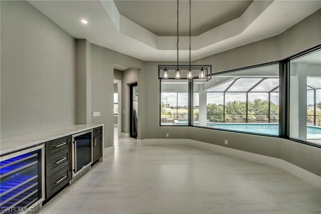 bar featuring a tray ceiling, pendant lighting, wine cooler, and plenty of natural light