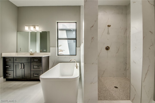 bathroom with shower with separate bathtub, large vanity, tile flooring, and tile walls