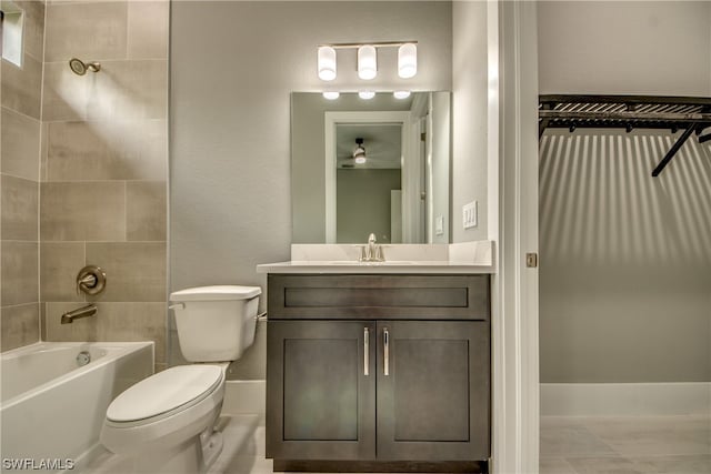 full bathroom with oversized vanity, toilet, tile floors, and tiled shower / bath