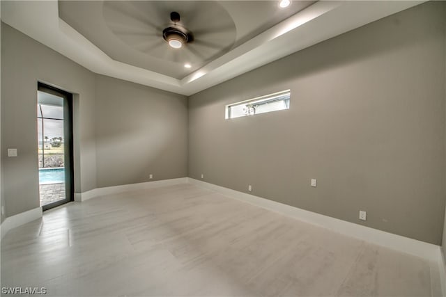 empty room with a raised ceiling and ceiling fan