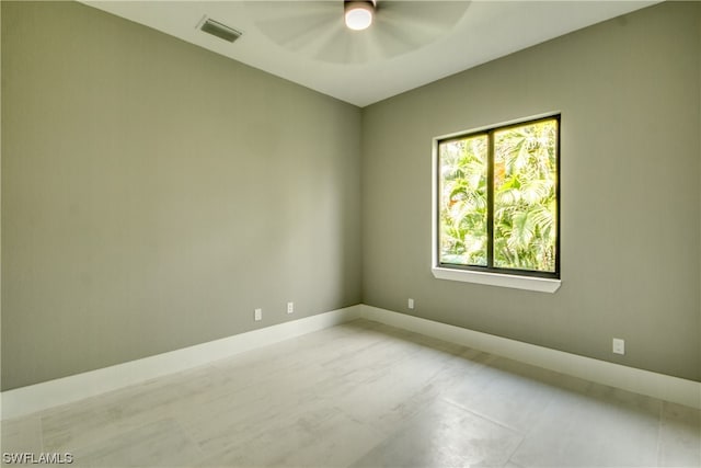 empty room with light tile flooring and ceiling fan