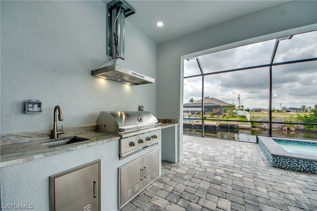 interior space with light stone countertops, white cabinetry, fume extractor, and sink