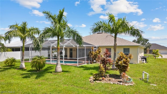 back of property with a lawn, glass enclosure, and a fenced in pool