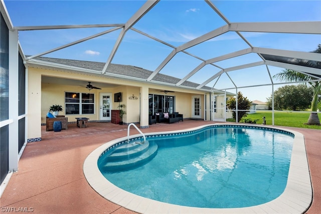 view of swimming pool featuring glass enclosure, ceiling fan, and a patio