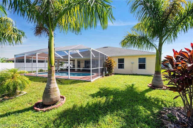 back of house with a lawn, a lanai, and a fenced in pool