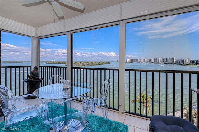 sunroom with a water view and ceiling fan