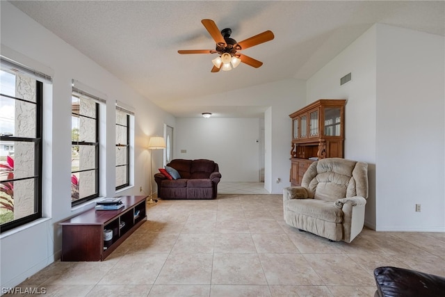 tiled living room with ceiling fan, lofted ceiling, and a textured ceiling