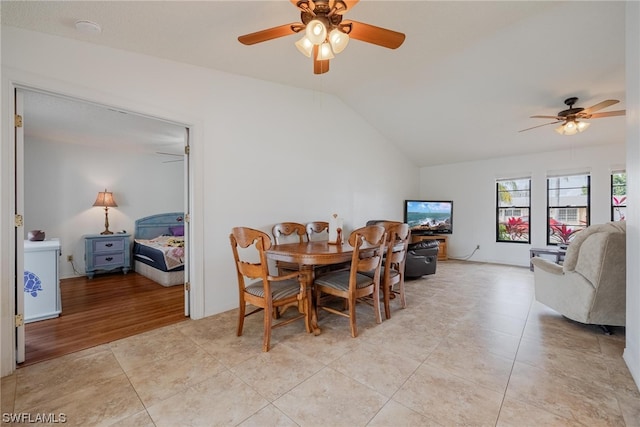 dining space featuring ceiling fan, lofted ceiling, and light tile patterned floors