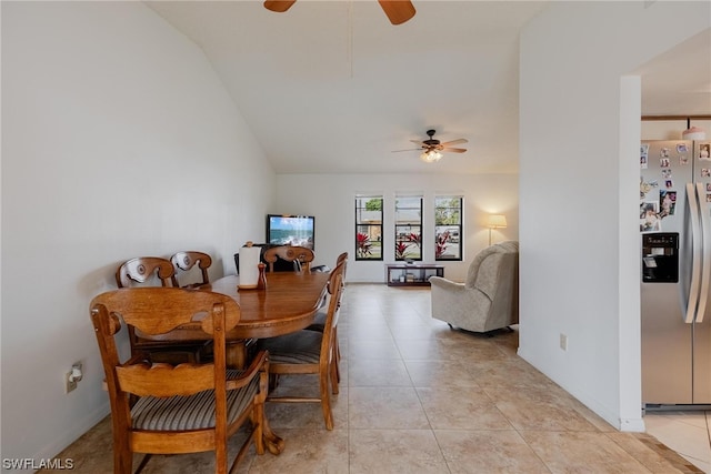 dining room featuring ceiling fan, light tile patterned flooring, and vaulted ceiling