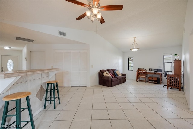 tiled living room featuring ceiling fan and lofted ceiling