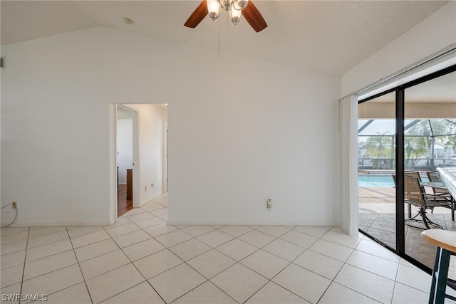 tiled spare room featuring ceiling fan and lofted ceiling