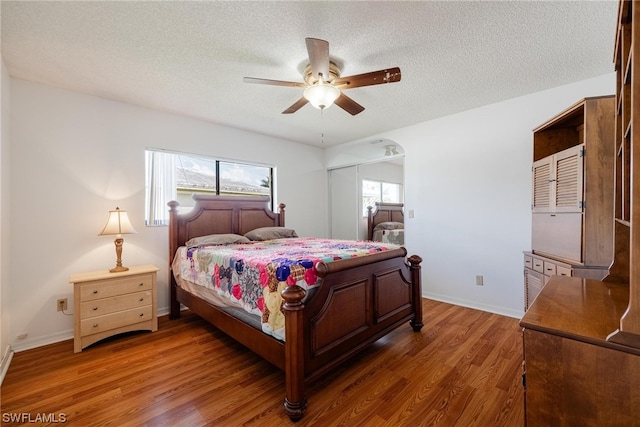 bedroom featuring a textured ceiling, dark hardwood / wood-style flooring, and ceiling fan