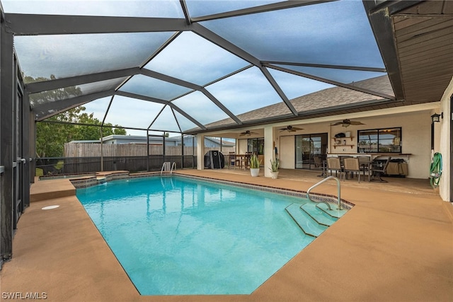 view of pool featuring glass enclosure, ceiling fan, and a patio area