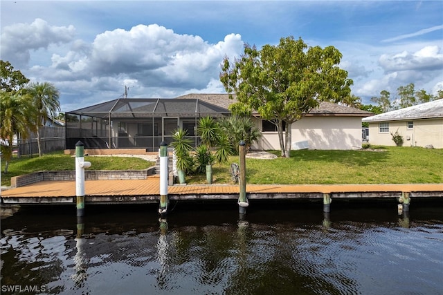 view of dock featuring a water view, glass enclosure, and a lawn