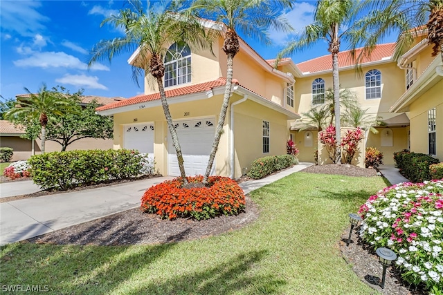 mediterranean / spanish home with a garage and a front lawn