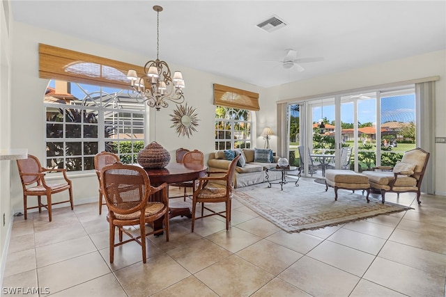 tiled dining room with ceiling fan with notable chandelier