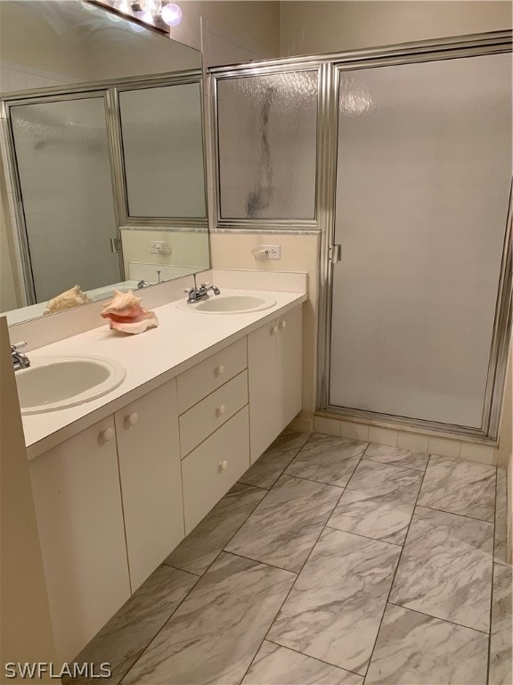 bathroom with tile floors, large vanity, double sink, and walk in shower