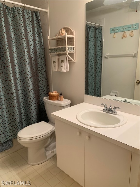 bathroom featuring tile flooring, toilet, and large vanity