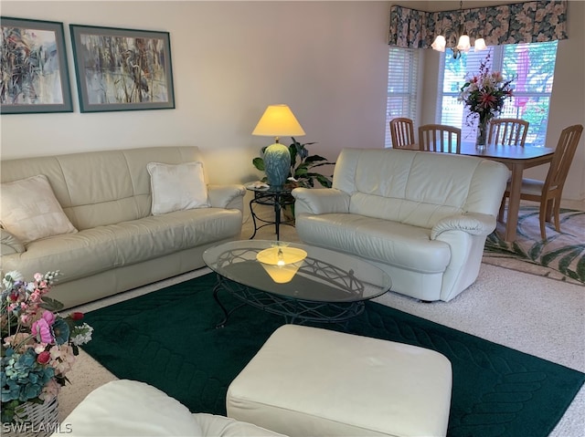 carpeted living room with an inviting chandelier