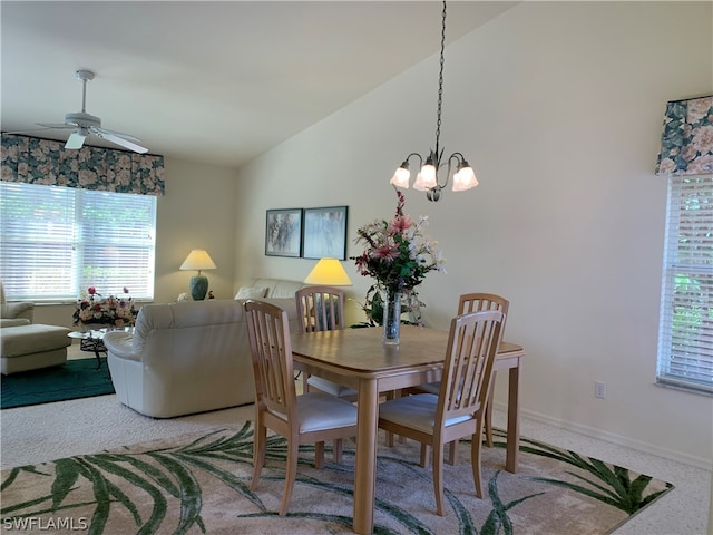 dining area featuring plenty of natural light, ceiling fan with notable chandelier, vaulted ceiling, and carpet