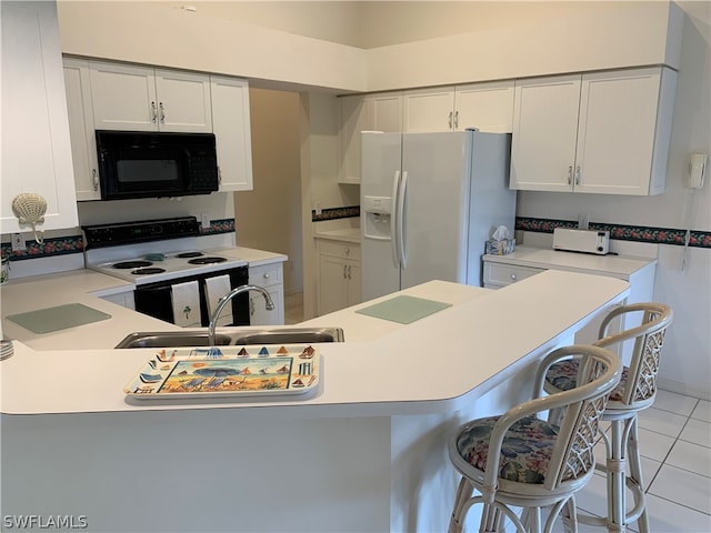 kitchen with kitchen peninsula, a kitchen bar, sink, white appliances, and light tile floors