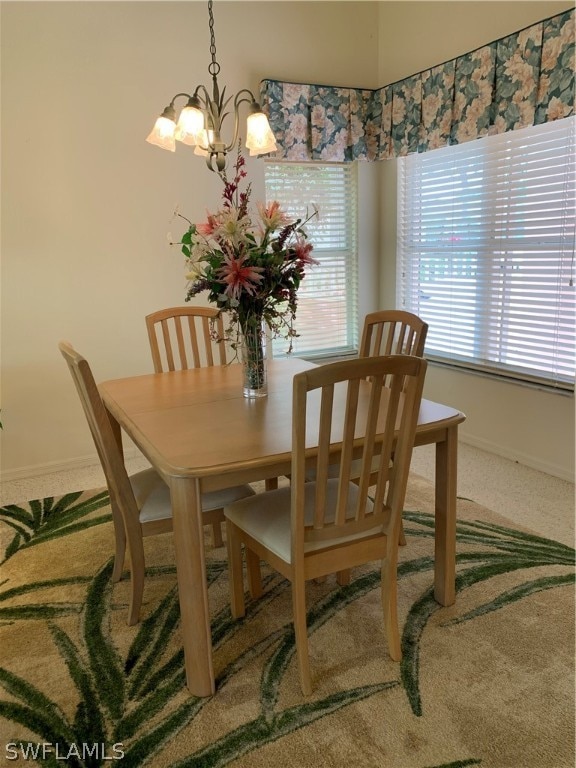 carpeted dining room featuring a notable chandelier