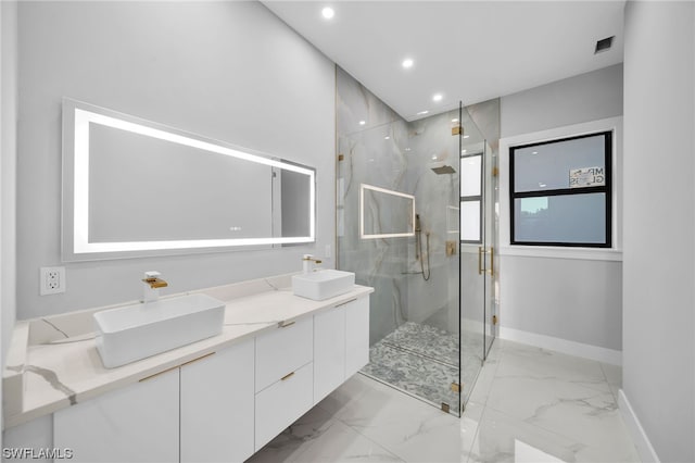 bathroom with oversized vanity, tile floors, dual sinks, and a shower with door