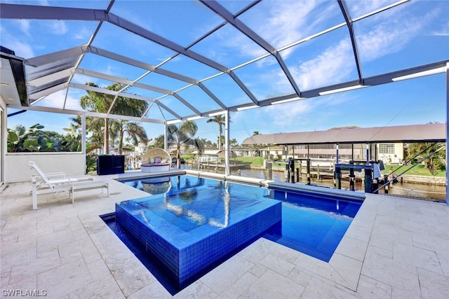 view of swimming pool with an in ground hot tub, a water view, glass enclosure, and a patio area