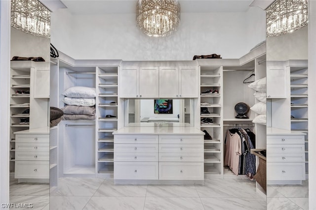 walk in closet featuring a notable chandelier