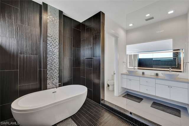 bathroom featuring vanity, toilet, a bathing tub, and tile patterned flooring