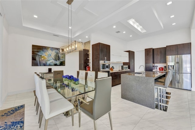 dining area featuring a high ceiling, a raised ceiling, and sink